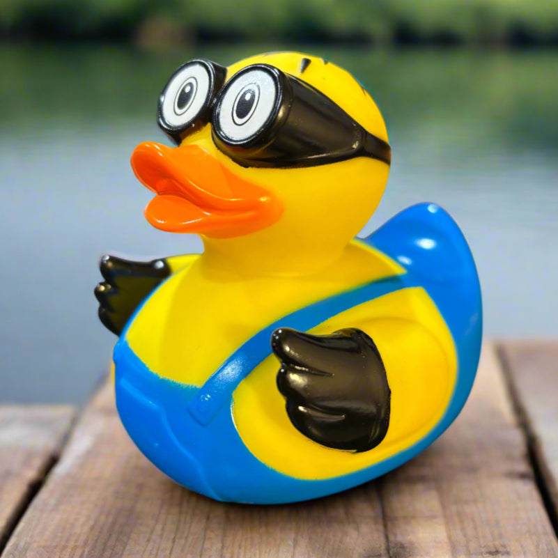 Rubber duck with  blue overalls and black hands attached to a wall