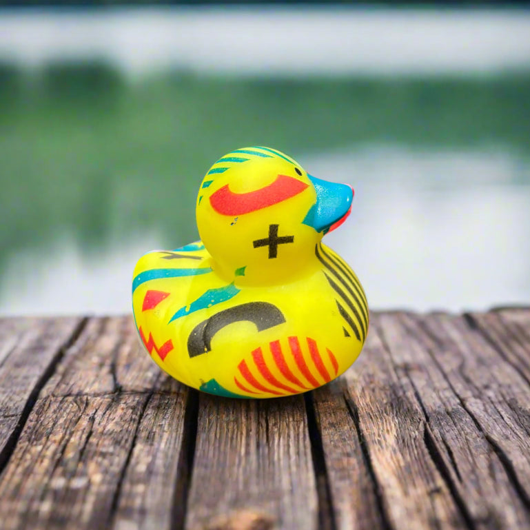 Colorful toy duck on a dark surface with a blurred background
