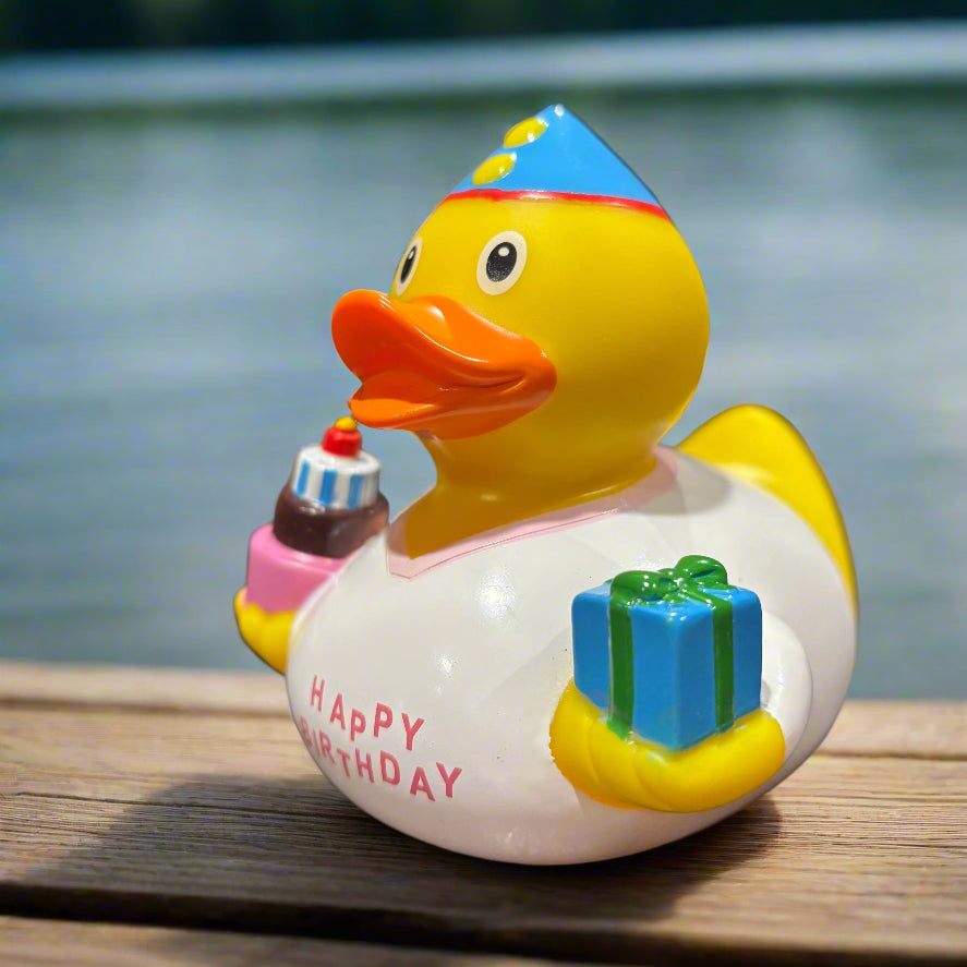 Colorful rubber duck with a 'Happy Birthday' message on a dark surface