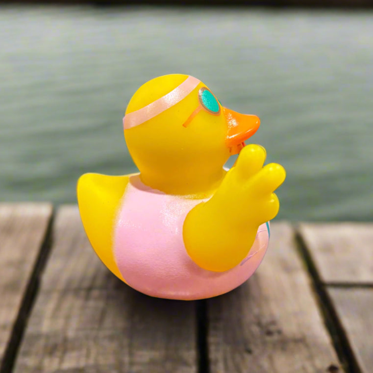 Yellow duck-shaped object on a dark surface with a blurred background