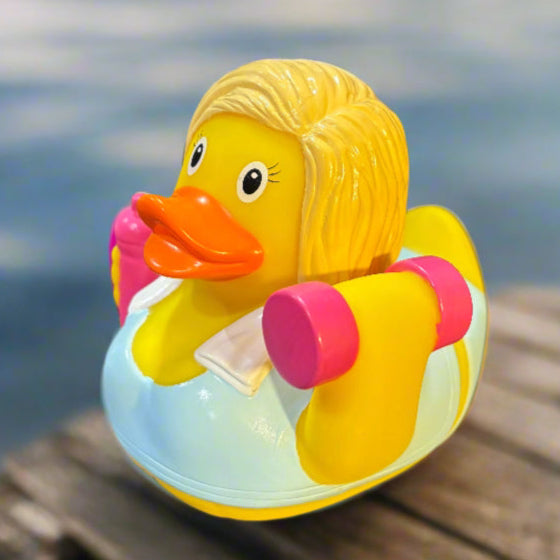 Colorful rubber duck with a pink bow on a dark surface