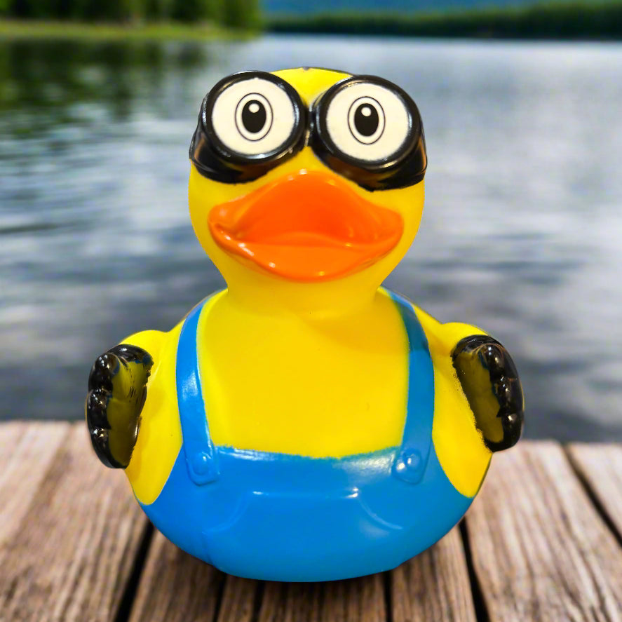 Yellow and blue rubber duck on a dark surface with a blurred background