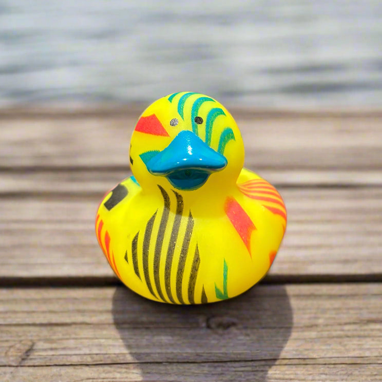 Colorful rubber duck on a wooden surface with water in the background