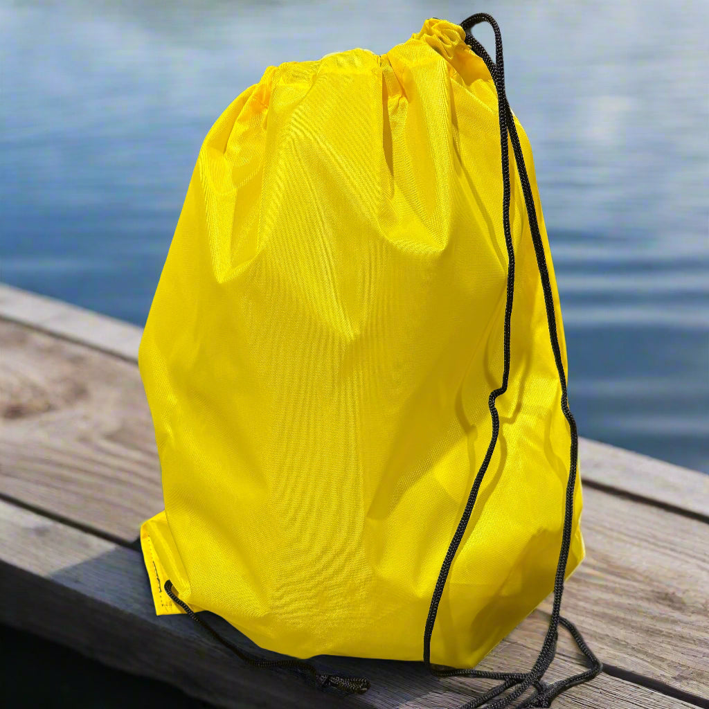 Yellow drawstring bag on a black surface with a blurred background