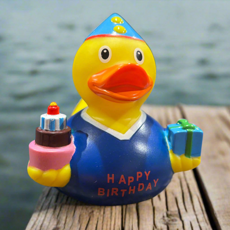 Colorful rubber duck with 'Happy Birthday' text on a dark surface