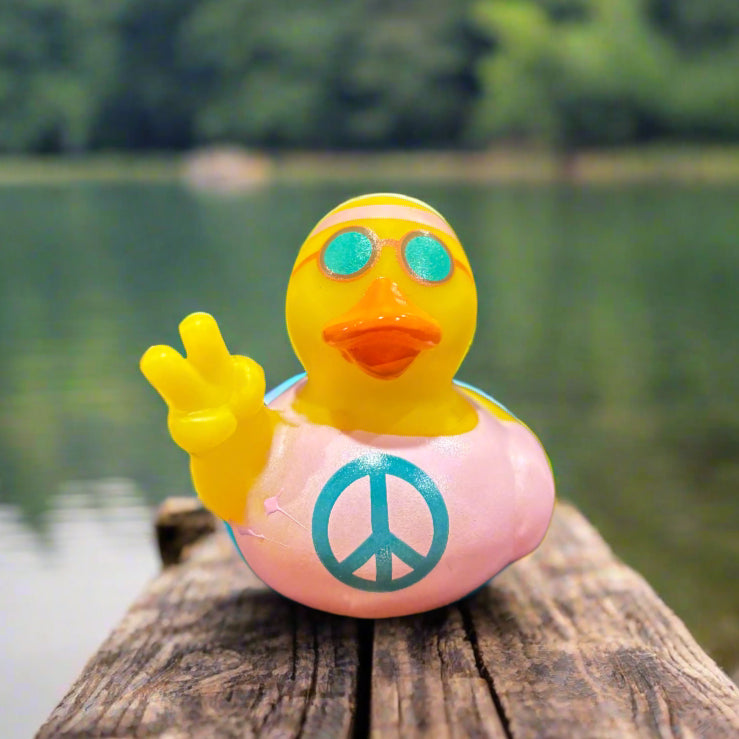 Small rubber duck with a peace symbol on a textured surface