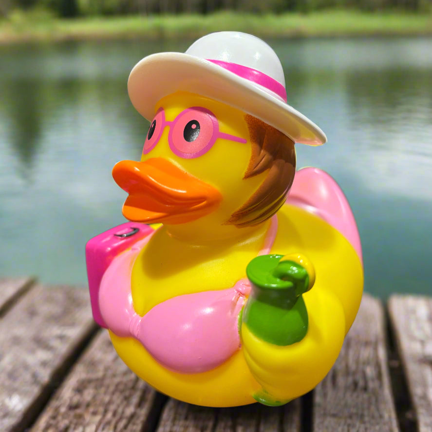 Colorful rubber duck-shaped toy with a hat on a dark surface