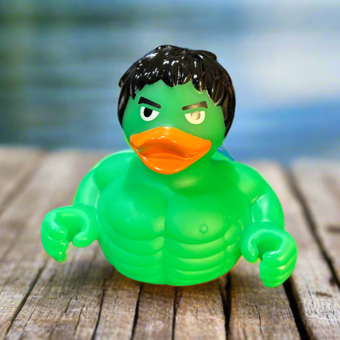 Green rubber duck with an orange beak on a dark surface