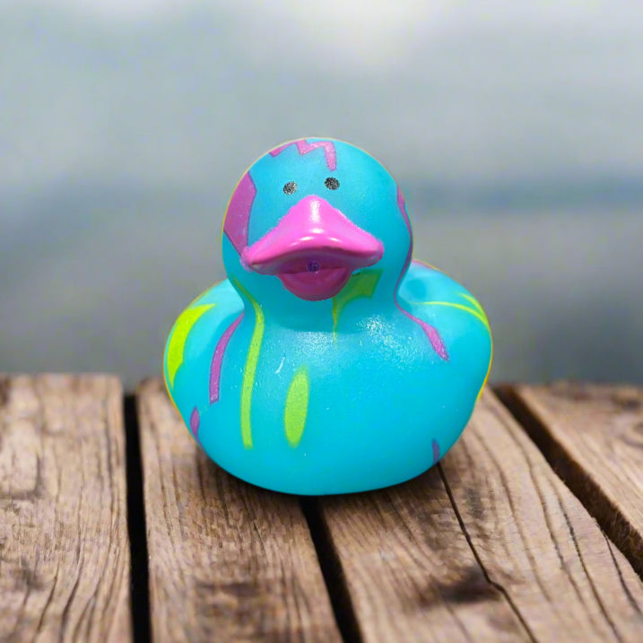 Colorful rubber duck on a wooden surface with a blurred natural background