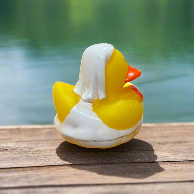 Rubber duck toy attached to a wooden surface with a blurred background